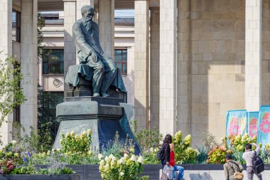 Moskova, Rusya - 13 Eylül 2019: Turistler, Moskova'nın tarih merkezindeki Rus devlet kütüphanesinin yakınında Rus yazar Fyodor Dostoyevski'nin anıtına karşı fotoğraf çektirdi
