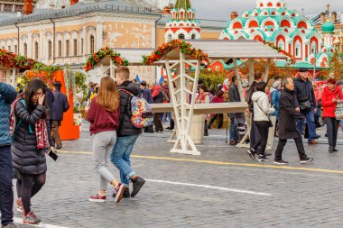 Moskova, Rusya - 05 Ekim 2019: İnsanlar Kızıl Meydan 'da Altın Sonbahar festivalinin dekorasyonlarına karşı yürüyorlar. Sonbaharda Moskova tarihi merkezi