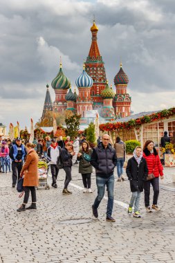 Moskova, Rusya - 05 Ekim 2019: İnsanlar Kızıl Meydan 'da geleneksel Altın Sonbahar festivalinin dekorasyonlarına karşı yürüyorlar. Moskova şehir merkezinde bulutlu bir sonbahar gününde