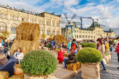 Moskova, Rusya - 05 Ekim 2019: İnsanlar Moskova 'nın tarihi merkezindeki Kızıl Meydan' da düzenlenen geleneksel Altın Sonbahar festivalinde güneşli bir sonbahar gününde samandan yapılmış banklarda dinleniyorlar