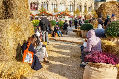 Moskova, Rusya - 08 Ekim 2019: İnsanlar Moskova 'nın tarihi merkezindeki Kızıl Meydan' da düzenlenen geleneksel Altın Sonbahar festivalinde güneşli bir sonbahar gününde samandan yapılmış banklarda dinleniyorlar