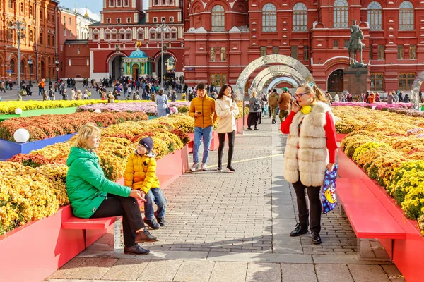 Moskova, Rusya - 08 Ekim 2019: Güneşli bir sonbahar gününde Moskova 'daki Manezhnaya Meydanı' nda düzenlenen geleneksel Sonbahar Festivali 'nde insanlar ara sokakta çiçekler arasında — Stok fotoğraf