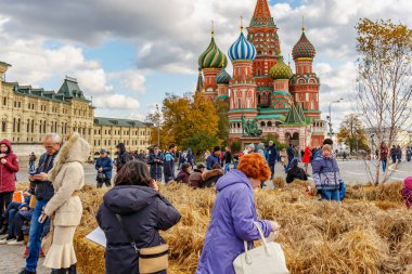 Moskova, Rusya - 08 Ekim 2019: Kızıl Meydan 'da bulutlu sonbahar gününde St. Basil Katedrali' ne karşı yürüyen turistler. Geleneksel festival Altın Sonbahar Moskova 'nın merkezinde
