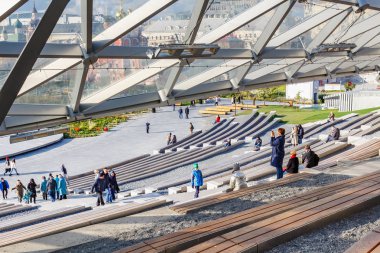 Moskova, Rusya - 08 Ekim 2019: Güneşli sonbahar gününde Büyük amfitiyatrodaki Zaryadye Parkı ziyaretçileri. Zaryadye Parkı Moskova 'da popüler bir turistik yerdir.