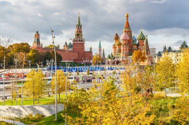 Moskova, Rusya - 08 Ekim 2019: Güneşli sonbahar gününde Moskova Kremlin ve Saint Basil Katedrali binaları. Zaryadye Parkı 'ndan renkli yapraklı ağaçlara bak
