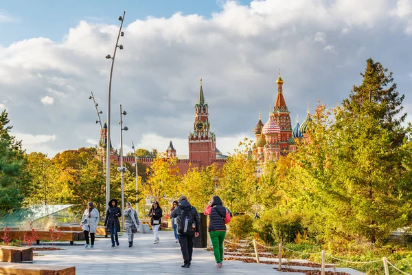 Moscow, Russia - October 08, 2019: Tourists walking along footpath in Zaryadye Park in Moscow at sunny autumn day. View on a Moscow Kremlin background — Stock Photo, Image