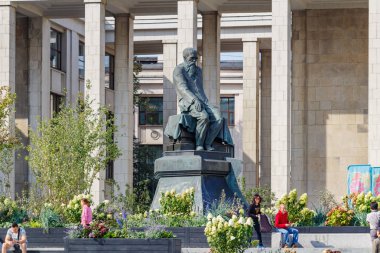 Moskova, Rusya - 13 Eylül 2019: Moskova şehir merkezinde Rus yazar Fyodor Dostoyevski 'nin anıtının yanında yürüyen turistler