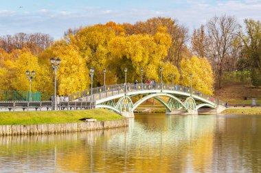 Moskova, Rusya - 16 Ekim 2019: Güneşli sonbahar gününde Tsaritsyno Parkı 'ndaki Orta Göl üzerinde yürüyen turistler. Tsaritsyno Park Moskova 'da popüler bir turistik yerdir.