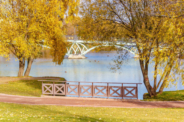 Москва, Россия - 16 октября 2019 года: Мост через пруд в Царицыно против золотых деревьев в солнечном свете. Популярное туристическое место Царицыно парк в Москве в солнечный осенний день
