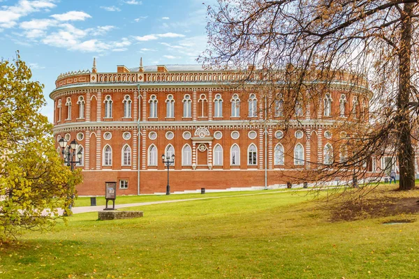 Moskou, Rusland - 16 oktober 2019: De gevel van het Broodhuisgebouw in het tsaritsyno park in Moskou tegen groen grasveld en blauwe lucht met witte wolken in de zonnige herfstdag. Tsaritsyno Park landschap — Stockfoto