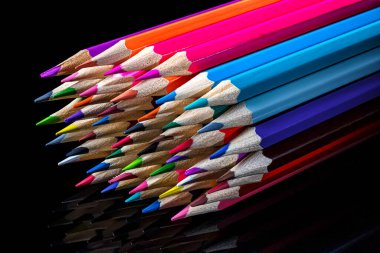 Siyah arkaplanda bir sürü renkli kalem var.