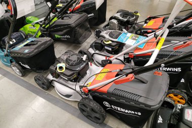 Moscow, Russia - August 17, 2019: Modern petrol and electric lawn mowers in a building materials hypermarket clipart