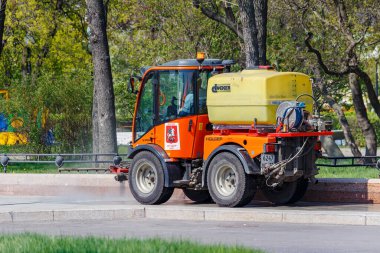 Moskova, Rusya - 01 Mayıs 2019: Güneşli bir bahar sabahı su yolu kaldırımında küçük bir fıskiye kamyonu temizlendi