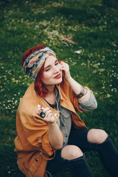 Smuk Pige Sidder Græsset Poserer Med Hovedtelefoner Fashionable Lykkelig Kvinde - Stock-foto