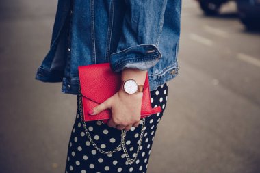 kırmızı çanta tutarak ve bir gül altın bilek saati denim ceket şık kadın. sokak stil moda