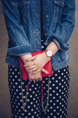 kırmızı çanta tutarak ve bir gül altın bilek saati denim ceket şık kadın. sokak stil moda