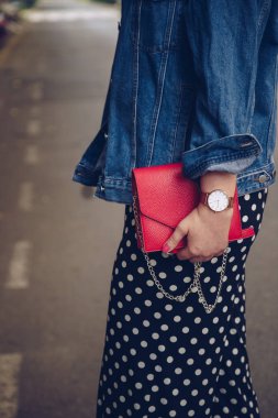 kırmızı çanta tutarak ve bir gül altın bilek saati denim ceket şık kadın. sokak stil moda