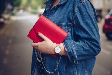 kırmızı çanta tutarak ve bir gül altın bilek saati denim ceket şık kadın. sokak stil moda