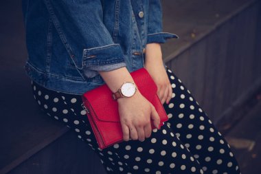 kırmızı çanta tutarak ve bir gül altın bilek saati denim ceket şık kadın. sokak stil moda