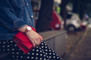kırmızı çanta tutarak ve bir gül altın bilek saati denim ceket şık kadın. sokak stil moda