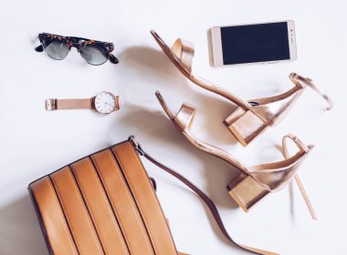 moda blog kavramı beyaz arka plan üzerinde. kadın aksesuarları: Altın Kol saati, orta ayak bileği kayış, deri toka çanta, cep telefonu ve leopar güneş gözlüğü ile topuk sandaletler en az sayıda düz lay