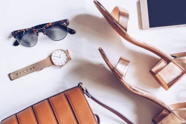 moda blog kavramı beyaz arka plan üzerinde. kadın aksesuarları: Altın Kol saati, orta ayak bileği kayış, deri toka çanta, cep telefonu ve leopar güneş gözlüğü ile topuk sandaletler en az sayıda düz lay