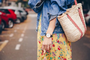 sokak tarzı moda ayrıntılar. trendy beach hasır çanta tutan bir yazlık elbise ve beyaz ve siyah analog kol saati, giyen kadın. mükemmel yaz 2018 moda aksesuarları. 