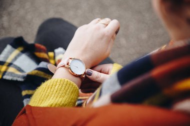 sokak tarzı moda ayrıntılar. yakın, bir kazak ve analog kol saati giyen genç moda blogger. şık kadın saati zamanında kontrol. Sonbahar/sonbahar sezon.