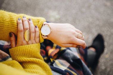 sokak tarzı moda ayrıntılar. yakın, bir kazak ve analog kol saati giyen genç moda blogger. şık kadın saati zamanında kontrol. Sonbahar/sonbahar sezon.