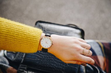 sokak tarzı moda ayrıntılar. yakın, bir kazak ve analog kol saati giyen genç moda blogger. şık kadın saati zamanında kontrol. Sonbahar/sonbahar sezon.