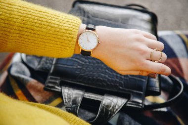 sokak tarzı moda ayrıntılar. yakın, bir kazak ve analog kol saati giyen genç moda blogger. şık kadın saati zamanında kontrol. Sonbahar/sonbahar sezon.