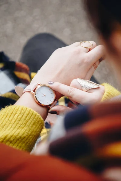 ストリート スタイル ファッションの詳細 間近で 若者のファッションのブロガーのセーターとアナログの腕時計を身に着けています スタイリッシュな女性彼女の時計の時刻をチェックします 秋のシーズン — ストック写真