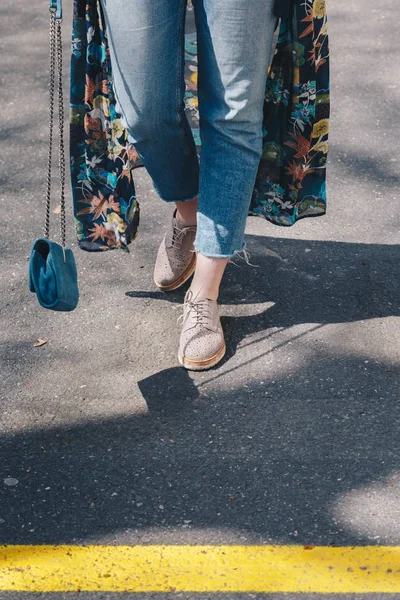 スエード ブルー革鞄をスイング通りを横断デニム ジーンズ ベージュの靴 花の着物ドレスを着てスタイリッシュな女性 — ストック写真