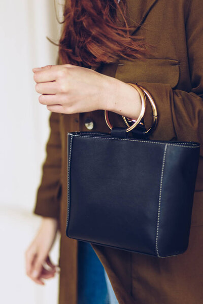 Street fashion portrait detail of professional woman's black leather purse