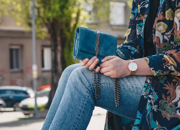 ストリート スタイル ファッションの詳細 間近で 若者のファッションのブロガー花ジャケットと白と金のアナログ腕時計を身に着けています 美しいスエードの革財布を保持している時間をチェック — ストック写真