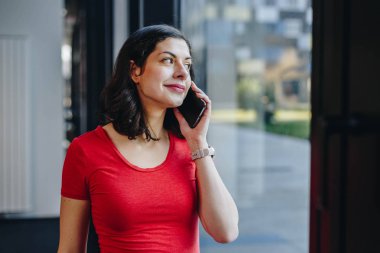 spor salonunda bir telefon görüþmesi güzel uygun kadın otantik portresi. egzersiz molası sırasında akıllı telefonda konuşurken kişisel koç