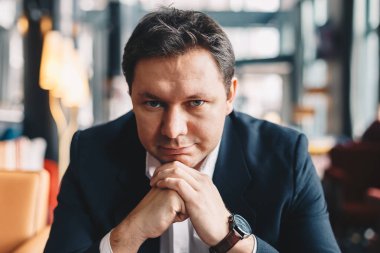 Yakın çekim ile bir barda oturmuş, kamera için poz yüksek benlik saygısı, iyi görünümlü genç işadamı portresi.