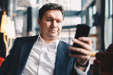 İyi görünüyor ve boş zamanlarında browsing belgili tanımlık enterne iş molası sırasında bir barda oturan şık genç adam.