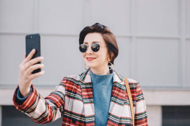 Cep telefonu görüntülü görüşme sahip, fantezi giyim eşyası ve uzun mesafeli arkadaşları ve familly için konuşmak güzel ve modern genç kadın portresi yakın çekim.