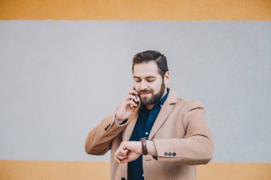 O zaman onun el gözetiminde arıyorum cep telefonundan bir kesinti sırasında konuşurken bir çekici ve modern genç adam portresi. Metin ve reklam alanı.