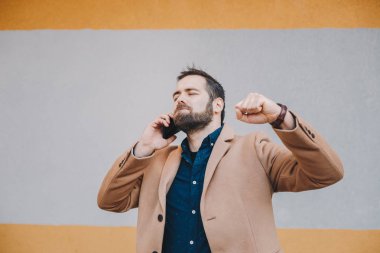 İyi haber dinledikten sonra exulting onun cep telefonuyla çekici ve modern genç freelancer portresi. Kopyalama, metin ve reklam için yer.