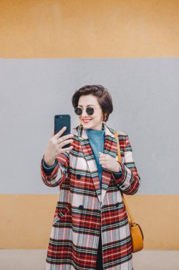 Sallayarak ve çevrimiçi takipçileri için söz ederken fantezi elbise giyen bir canlı video akışı onun akıllı telefon üzerinden sahip güzel, modern genç etki unsuru portresi. Kopyalama, metin ve reklam için yer.