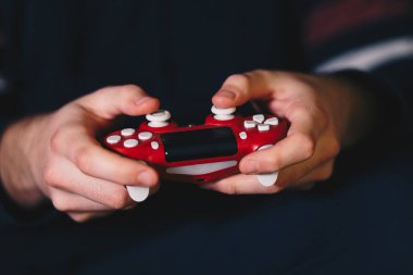 Close up of male hands holding a joystick and playing video games. clipart