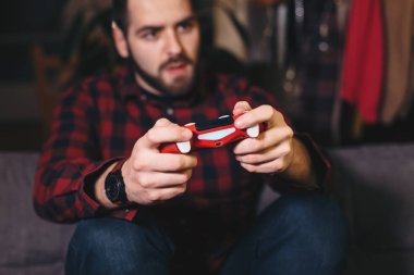 İskambil video spor dairesinde, yakışıklı bir adam portresi vurguladı ve ilerleme üzerinde duruldu. Video oyun denetleyicisi üzerinde odaklanmak.