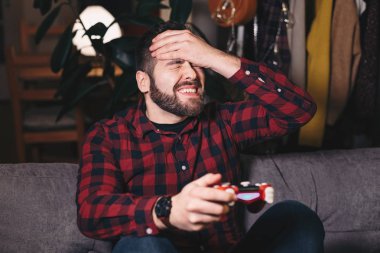 Video oyunları evde oynarken, kaybeden genç bir adam portresi. Olmak hayal kırıklığına uğramış ve sonuçları ile sinirli.