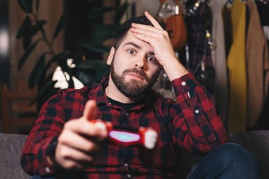 Video oyunları evde oynarken, kaybeden genç bir adam portresi. Olmak hayal kırıklığına uğramış ve sonuçları ile sinirli.