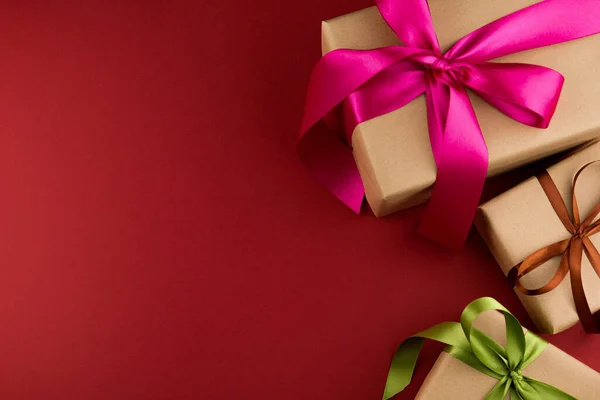 Drei Geschenkboxen Bastelpapier Und Gebunden Mit Farbigen Bändern Auf Rotem — Stockfoto