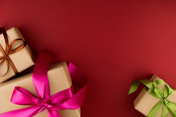 Drei Geschenkboxen Bastelpapier Und Gebunden Mit Farbigen Bändern Auf Rotem — Stockfoto