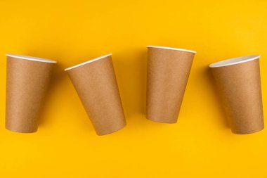 Çevresel fast food kavramı. Sarı arka planda, fotokopi alanı olan üç karton çevre dostu malzeme..