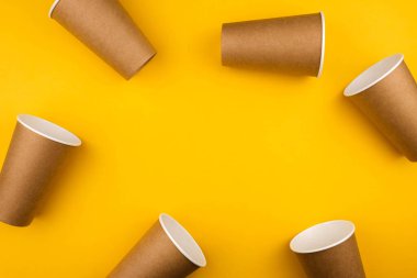 Çevresel fast food kavramı. Sarı arka planda, fotokopi alanı olan üç karton çevre dostu malzeme..